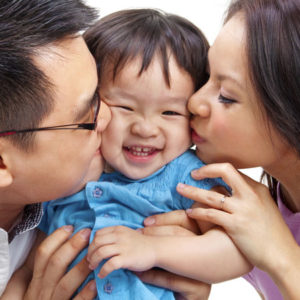 Couple Kissing Smiling Child